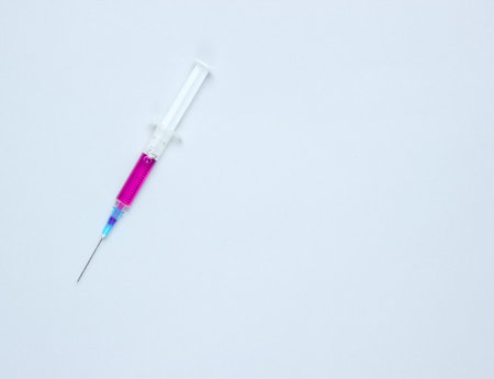 Medical concept, injection, vaccination. Syringe with purple liquid on gray background. Copy spaceの写真素材
