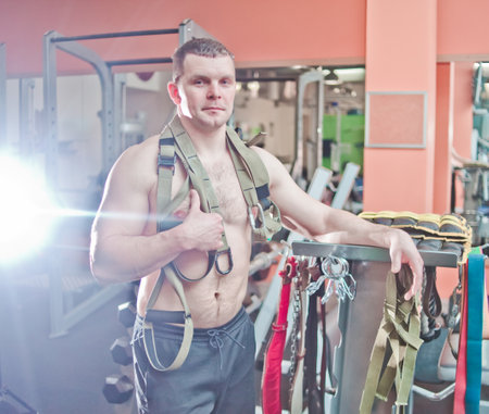 Athletic man with nude torso posing in gymの写真素材