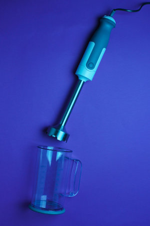 Electric hand blender with jar on dark blue light background. Top view, Flat layの写真素材