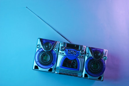 Retro wave, 80s. Audio cassette recorder with antenna and speakers in holographic light. Top view, minimalismの写真素材