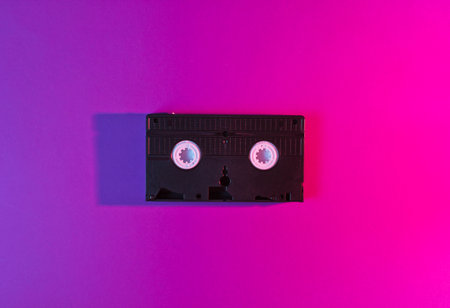 Retro wave style video cassette with vibrant gradient pink blue neon  lights. 80s. Top viewの写真素材