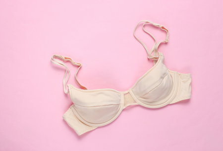 Beige feminine bra on a pink background. Top view, minimalismの写真素材