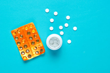 Minimalism medical concept. Blisters and a bottle of pills on a blue background.の写真素材