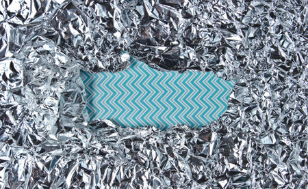 Torn Frame of crumpled foil with blue space for infirmation. Copy space