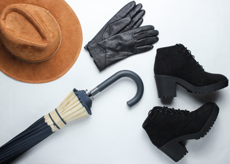 Autumn women's accessories. Leather gloves, felt hat, umbrella, boots on a white background. Top view.の写真素材