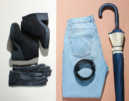 Autumn flat lay women's clothing accessories and shoes on a beige brown background. Boots, umbrella, gloves, beltの写真素材