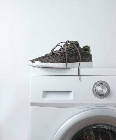 Sport sneakers on washing machine against a white backgroundの写真素材