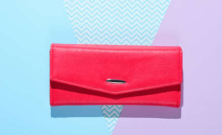 Red leather wallet on pastel background. Top view