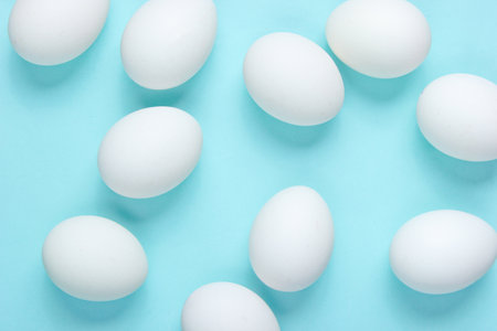 Minimalism food concept. A lot of eggs on a blue background. Top viewの写真素材