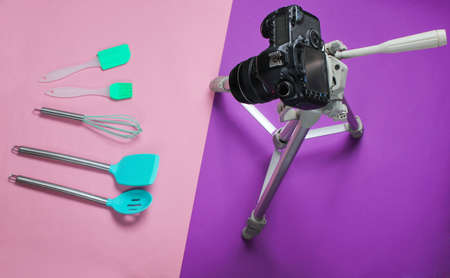 Culinary video blog. Paddles for cooking, camera on a tripod on a purple background. Top view