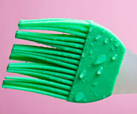 Silicone kitchen brush for cooking in drops of water on pink backgroundの写真素材