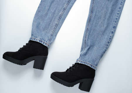 Fashion look. Jeans with boots on gray background. Top view
