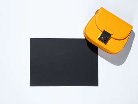 Black sheet of paper for copy space, yellow bag on gray background. Creative fashion backgroundの写真素材