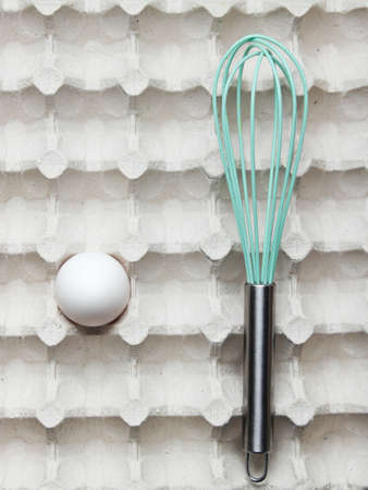 Whisk and eggs in tray. Top view, closeupの写真素材