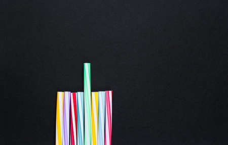 Lot of multi-colored cocktail tubes on black background. Top viewの写真素材
