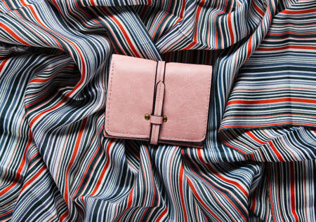 Pink leather wallet on fabric background. Top viewの写真素材