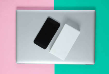 The concept of unboxing, techno blogging. Box with a new smartphone, laptop on pastel background.の写真素材