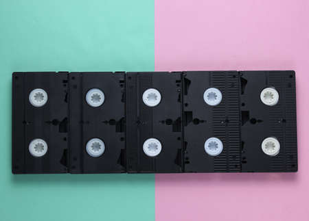 A lot of video tapes on pastel background. Top view