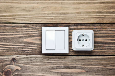 Power socket and switch on wooden wall, minimalism