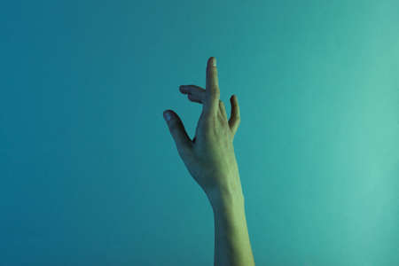 Female hand with blue holographic color light. Minimalism fashion. Surrealism. Concept artの写真素材