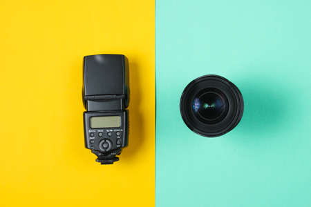 Lens with flash on a colored paper background. Top view