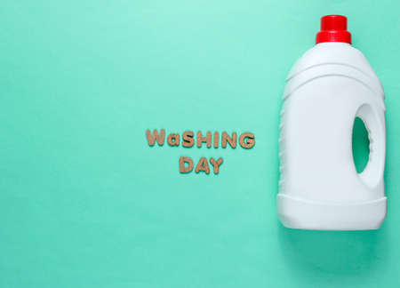 Bottle of washing gel on blue background with the text washing day. Top view. Minimalismの写真素材
