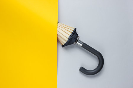 Umbrella hook hidden behind yellow paper sheet. Minimalism fashion concept. Top viewの写真素材