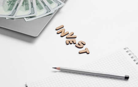 Creative business concept. Laptop, notebook,  pencil, dollar bills on white background with the word...