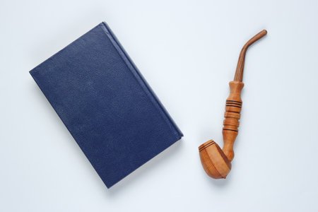 Vintage style. Old book, smoking pipe on yellow background. Top view, minimalismの写真素材