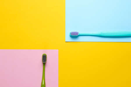 Two new toothbrushes on a colored paper background. Minimalism hygiene conceptの写真素材