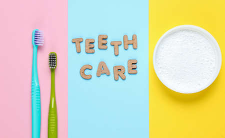 Two toothbrushes, tooth powder on colored background with slogan teeth care. Minimalism oral hygiene concept. Top viewの写真素材