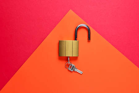 Lock and key on red-orange background. Minimalistic concept. Top viewの写真素材