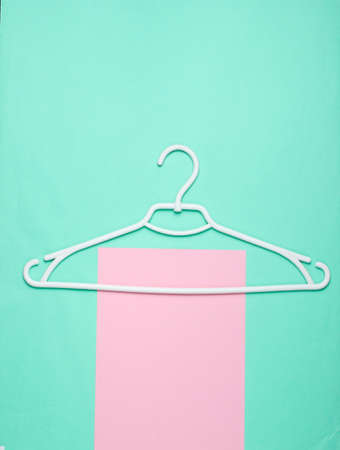 White plastic hanger on blue pink background. Top viewの写真素材