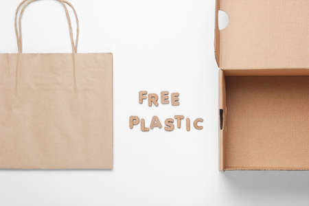 Ecological concept. Empty cardboard box, paper bag on a white background with the word free plastic....