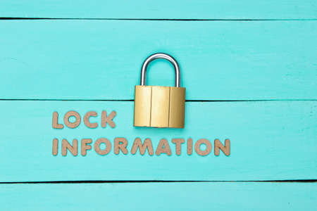 Lock your information. Lock on blue wooden background. Minimalistic concept.の写真素材