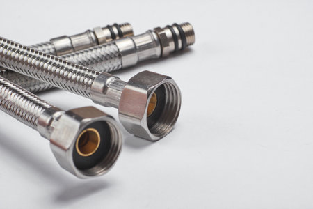 Two metal plumbing hoses on a white backgroundの写真素材