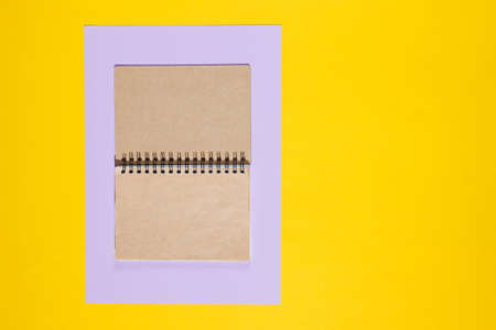 Kraft paper notepad on yellow background. Top viewの写真素材