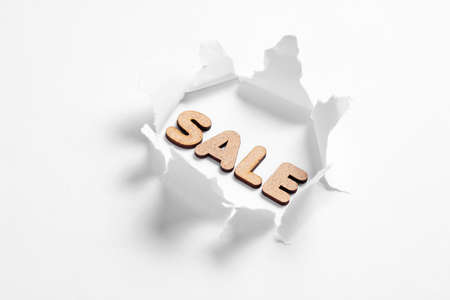 Word sale in torn hole on white background. Minimal shopping conceptの写真素材