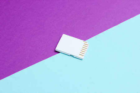 Mini SD memory card on blue purple paper background close upの写真素材