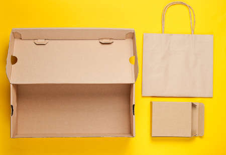 Eco concept. Cardboard boxes, paper bag on yellow background. Top viewの写真素材