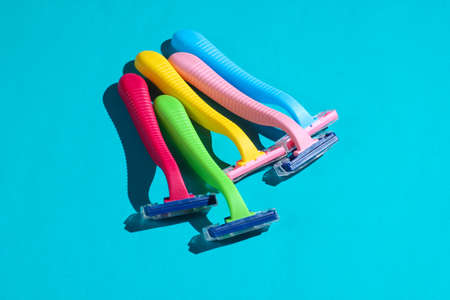 Beauty and fashion pop art concept. Many colored plastic razors on blue background. Minimalismの写真素材