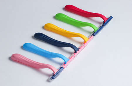Many colored plastic razors on white background.