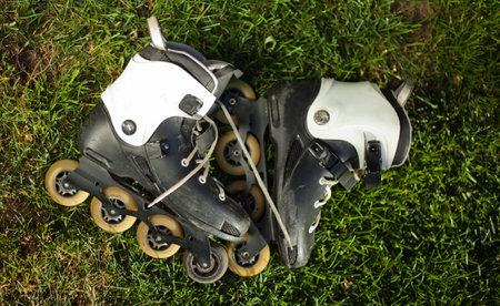 Old roller skates on the lawn grass. Top view. Sport concept