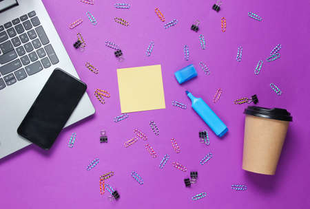 Minimalistic office still life. Laptop, stationery (paper clips, felt-tip pen, memo piece of paper),...
