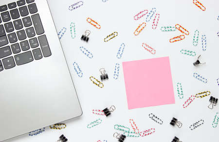 Minimalistic office still life. Laptop, stationery (paper clips, felt-tip pen, memo piece of paper)...