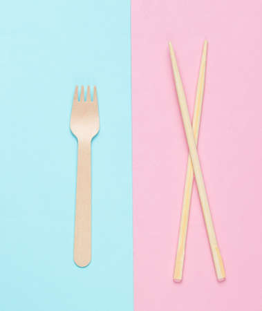 Eco cutlery. Chinese chopsticks, wooden fork on blue pink pastel background. Top viewの写真素材