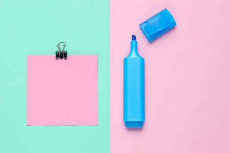Stationery office supplies. Paper clip, felt-tip pen, memo piece of paper on pink blue pastel the backgroundの写真素材