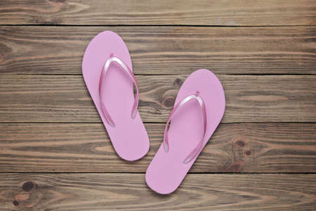 Tropical beach lifestyle. Pink Flip flops on wooden background. Summer background. Top viewの写真素材