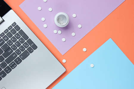 Medical background. Workspace of modern doctor. Laptop, pills on colored pastel background. Top view. Flat layの写真素材