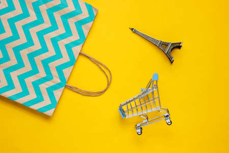 Mockup with shopping cart and paper bag on yellow background. Happy customer concept. Internet shopping. Online store. Consumerism, lifestyleの写真素材